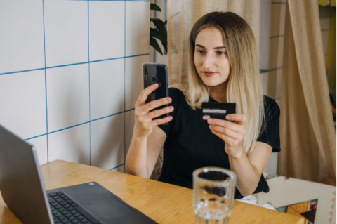 Woman at home using credit card and laptop